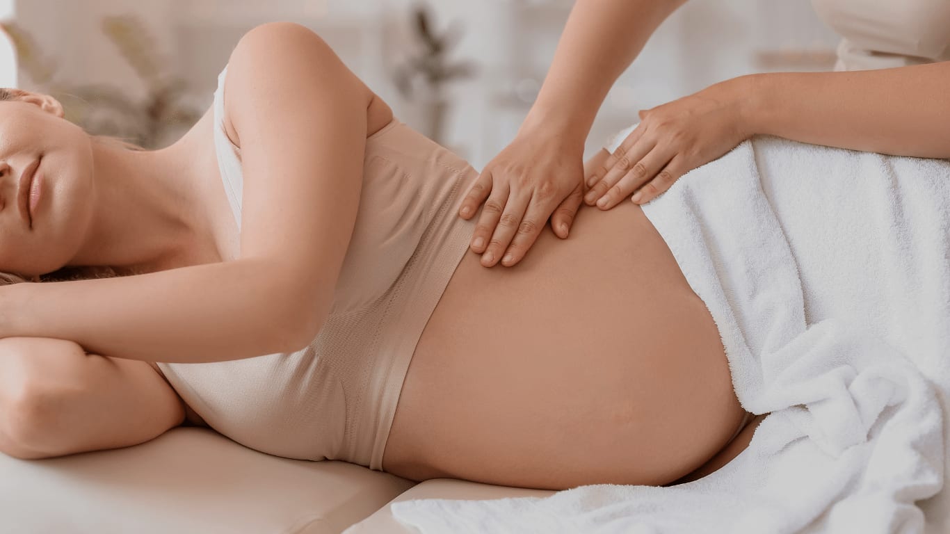 Schwangere Gästin erhält eine sanfte Massage im unteren Rückenbereich